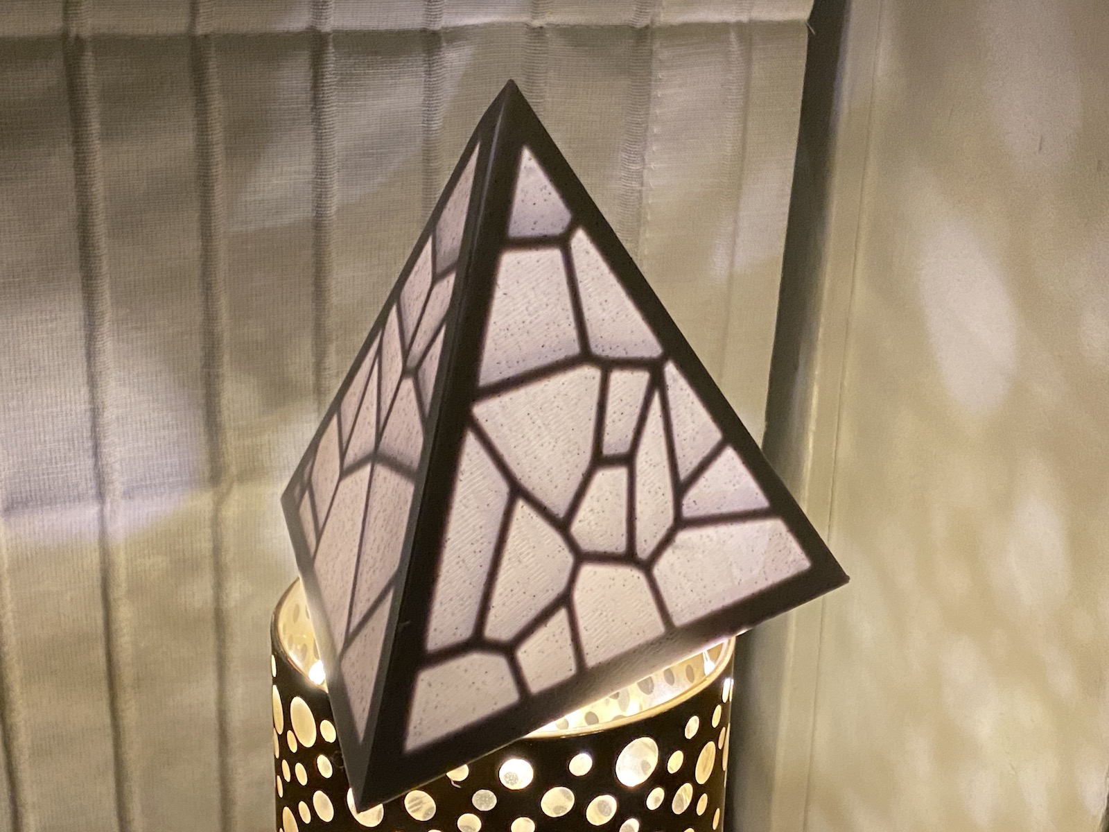 a 3d printed pyramid lit up from inside with lights.